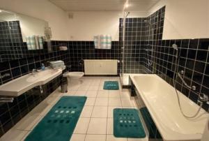 y baño con bañera, lavabo y aseo. en Ferienwohnung Kessler, en Ommersheim