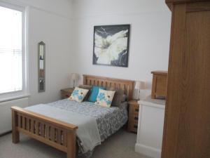 a bedroom with a bed with blue pillows on it at Lovely Spacious 3 Bedded First Floor Apartment in Ryde