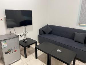 un soggiorno con divano blu e TV a schermo piatto di الشقق الذكية a Yanbu