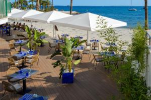 un patio con mesas y sillas en la playa en Hotel Vibra Marítimo, en Ibiza