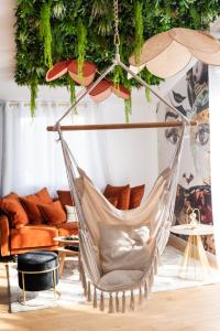 una hamaca en la sala de estar con sofá en La Charmeuse (Suite privée pour amoureux, en Belin-Beliet