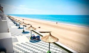 rząd parasoli na plaży z oceanem w obiekcie MyChoice Aitana w mieście Rota