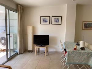 a living room with a television and a table at Belmar in Les Cases d'Alcanar