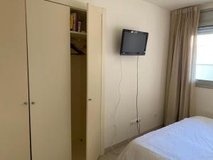a bedroom with a bed and a tv on the wall at Belmar in Les Cases d'Alcanar