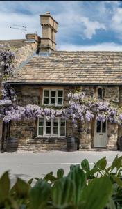 un edificio de piedra con flores púrpuras. en Chantry House en Barnsley