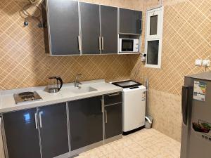 a small kitchen with a sink and a refrigerator at الشقق الذكية in Yanbu