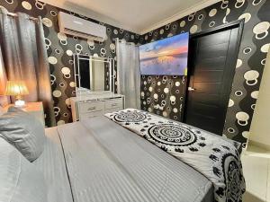 a bedroom with a bed and a dresser and a mirror at Apartamento Cómodo & Seguro in Santo Domingo