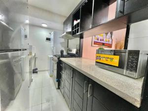 a kitchen with a counter top with a microwave at Apartamento Cómodo & Seguro in Santo Domingo