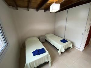 a room with two beds in a white room at Hermoso Departamento mendoza capital in La Cieneguita