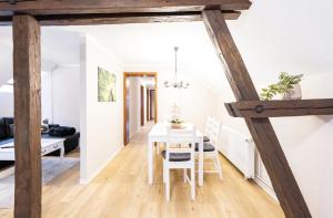 a dining room and living room with a white table and chairs at Ferienwohnung Ziesing Gernrode in Gernrode - Harz