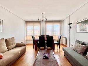 ein Wohnzimmer mit einem Sofa und einem Esstisch in der Unterkunft Housingleón - Conde Duplex con garaje gratuito in León