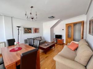 ein Wohnzimmer mit einem Sofa und einem Esstisch in der Unterkunft Housingleón - Conde Duplex con garaje gratuito in León
