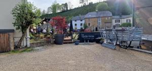 un mercado en un pueblo con un edificio y una valla en La Vieille Ferme Chassepierre, en Chassepierre