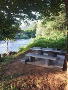 a picnic table sitting next to a river at vila Nikolaj in Niš