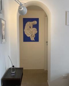 un couloir avec une statue sur le mur et une table dans l'établissement Il Giardino d'Ulisse, à Reggio de Calabre