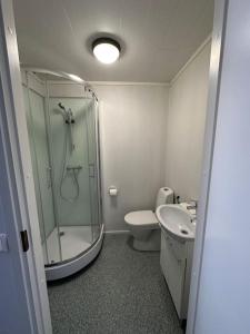 a bathroom with a shower and a toilet and a sink at Varastotie 1A in Ylivieska