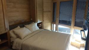 a bedroom with a white bed and a window at Woody Studio Les Menuires in Levassaix +2 photos