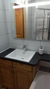a bathroom with a sink and a mirror at Woody Studio Les Menuires in Levassaix