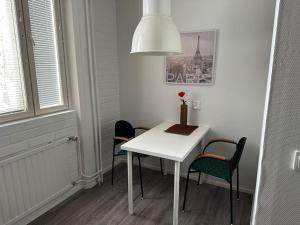 a white table and chairs in a room with a lamp at Varastotie 1A in Ylivieska