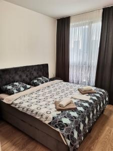 ein Schlafzimmer mit einem Bett mit zwei Handtüchern darauf in der Unterkunft Aurora BW in Belgrad