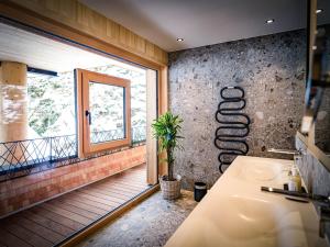 HAUSEREI Design & Kräuterhotel في ستيغ: حمام مع حوض ونافذة
