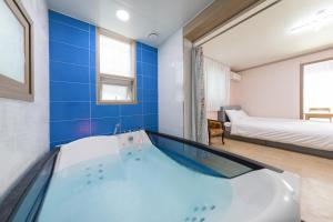 uma casa de banho com banheira e uma cama num quarto em Clear morning pet friendly pension em Gyeongju