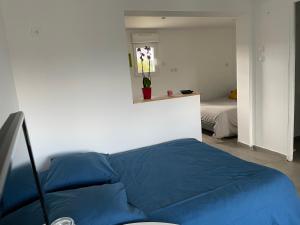 ein blaues Bett in einem Zimmer mit einem Schlafzimmer in der Unterkunft La belle étoile in Roye
