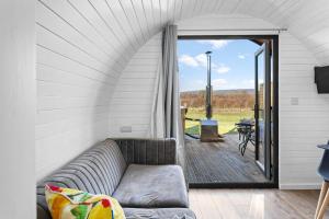 uma sala de estar com um sofá e um pátio em Honeycrisp, Apple Tree Glamping, Nr Wells em Wells