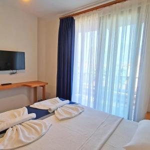 a bedroom with a bed with a tv and a window at Akcapinar Korfez Butik Otel in Akyaka