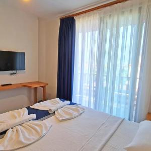 アクヤカにあるAkcapinar Korfez Butik Otelのベッドルーム1室(ベッド1台、テレビ、窓付)