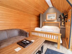 a small room with a bed and a couch at Acorn Lodge At Bridge Lake Farm & Fishery in Banbury