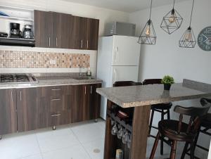 a kitchen with wooden cabinets and a counter top at Condominio Palma Real in Granada