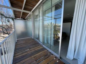 a balcony with glass doors and a wooden deck at Tacha in Buenos Aires