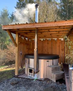 a wood fired outdoor oven with a roof at Wild Cube in Durbuy