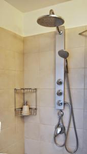 a shower with a shower head in a bathroom at Peled House of Art in Mevasseret Zion