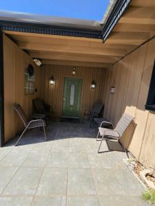 a patio with rocking chairs and a green door at Home of the Brave 2 in Lawton