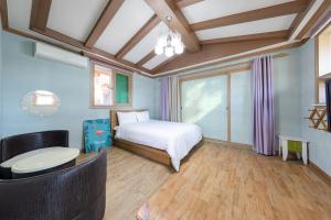 a bedroom with a bed and a table and a window at Clear morning pet friendly pension in Gyeongju