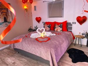 a bedroom with a bed with hearts on the wall at BIOTY CHILL & SPA in Le Blanc-Mesnil
