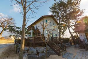 a house with a porch and a tree at Clear morning pet friendly pension in Gyeongju