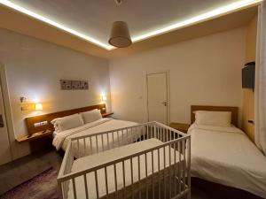 1 dormitorio con 2 camas y 1 cuna en AL BON Park, en Berat