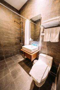 a bathroom with a toilet and a sink and a mirror at 中央旅社 in Magong