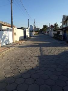 una calle adoquinada con una valla blanca en Cantinho da kel, en Bombinhas