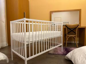 a white crib in a room with a mirror at AL BON Park in Berat +30 photos