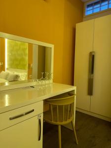Habitación amarilla con escritorio con espejo y silla en AL BON Park, en Berat