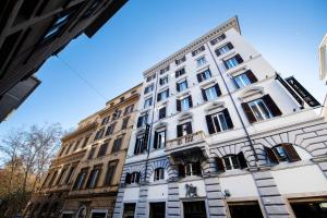 un grand bâtiment blanc avec des fenêtres sur une rue dans l'établissement Hotel 77 Seventy-Seven - Maison D'Art Collection, à Rome