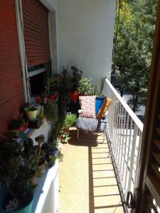Un balcón con una silla y macetas. en Nora Espejo en Mendoza