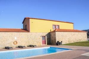 a villa with a swimming pool in front of a building at Quinta das Areias - Solar da Pena in Braga