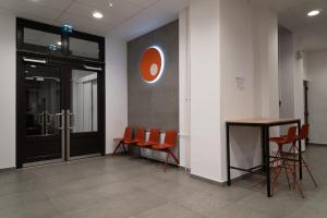eine Bürolobby mit orangefarbenen Stühlen und einem Tisch in der Unterkunft Equity Point Budapest in Budapest