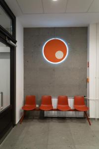 a row of orange chairs in a waiting room at Equity Point Budapest in Budapest