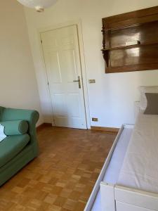 sypialnia z zieloną kanapą i białymi drzwiami w obiekcie MAGGIE HOUSE w Rzymie